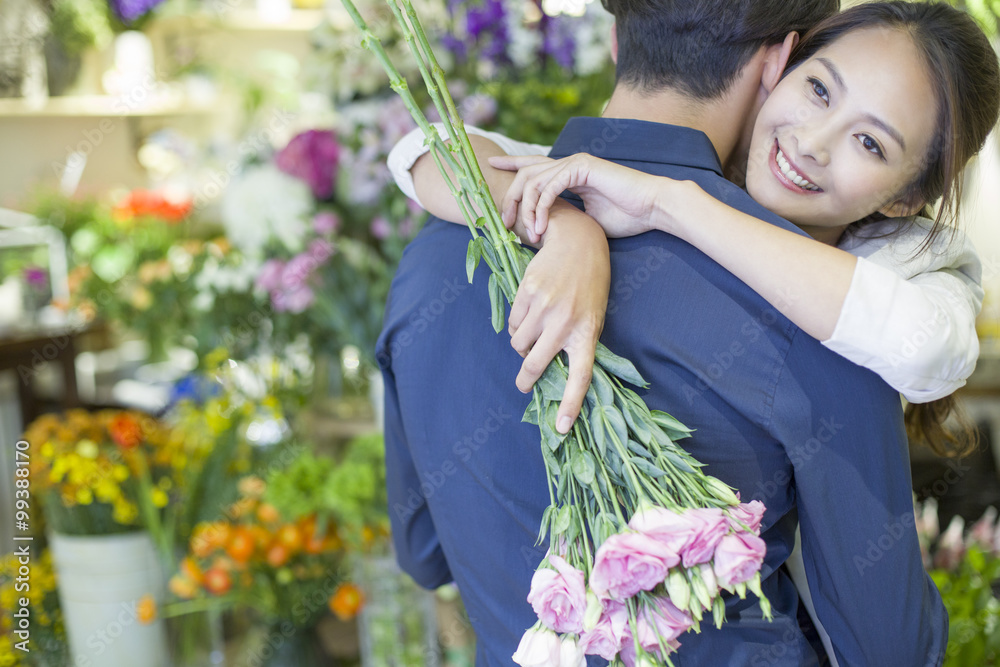 年轻女子用鲜花拥抱男友