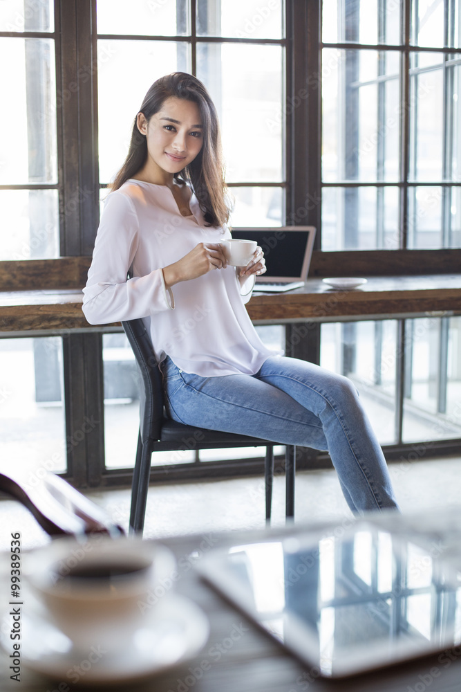 Young woman drinking coffee in cafe