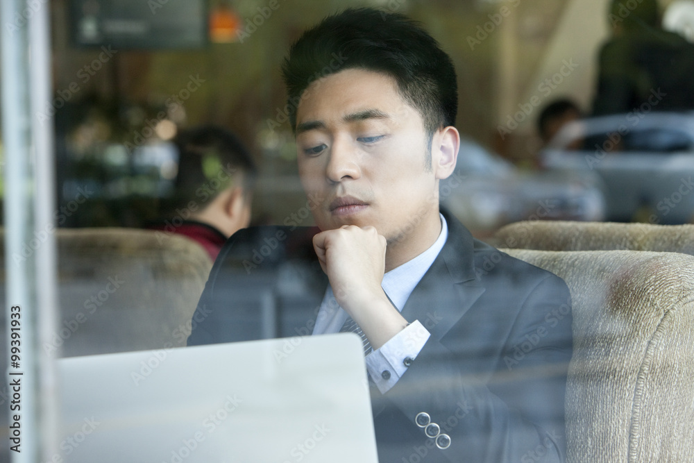 Businessman using laptop in cafe