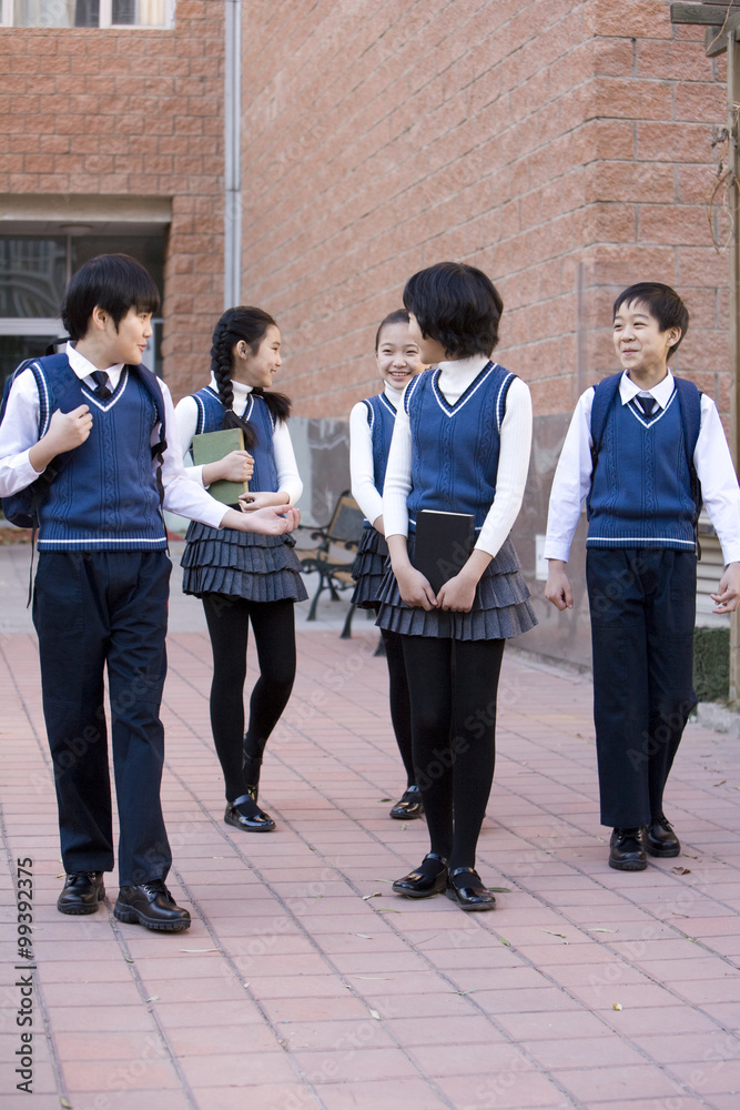 Five classmates walking around campus