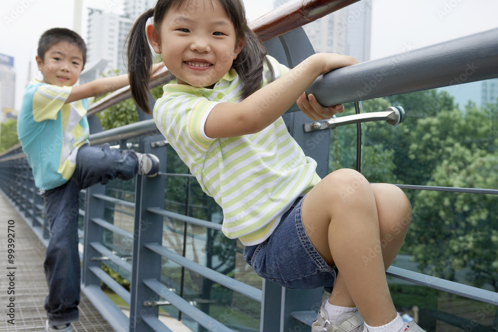 年轻的男孩和年轻的女孩在公园里爬桥