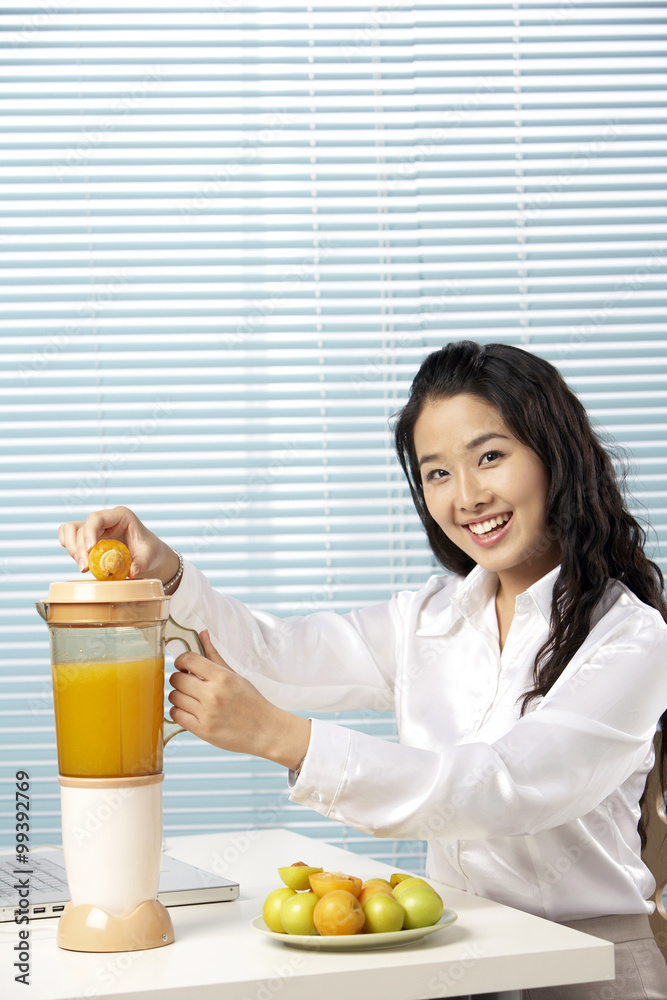 年轻女子用搅拌机制作果汁