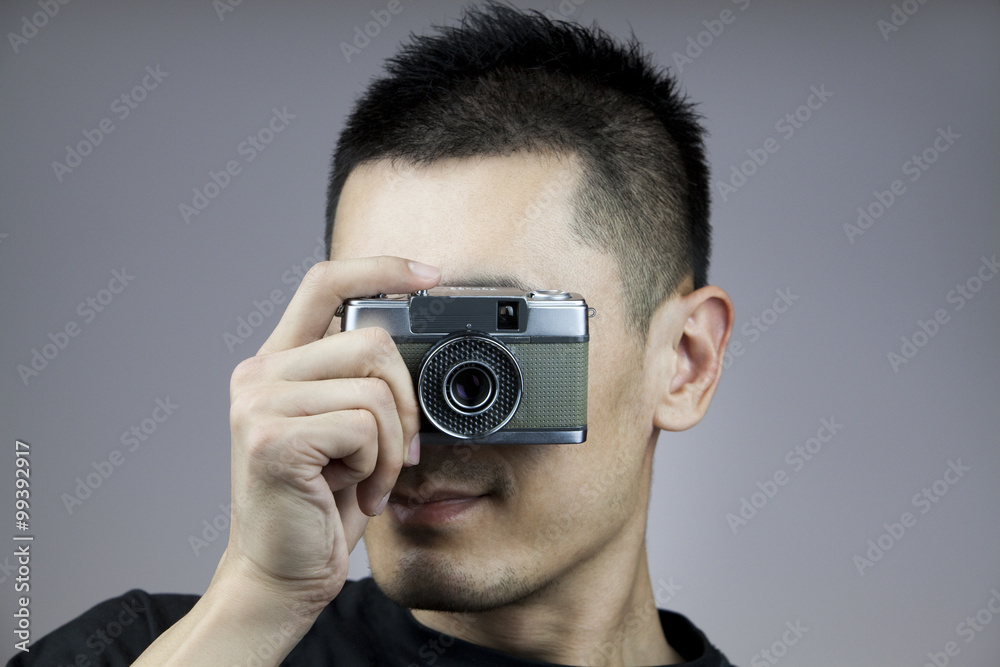 Young man taking photos with old-fashioned camera