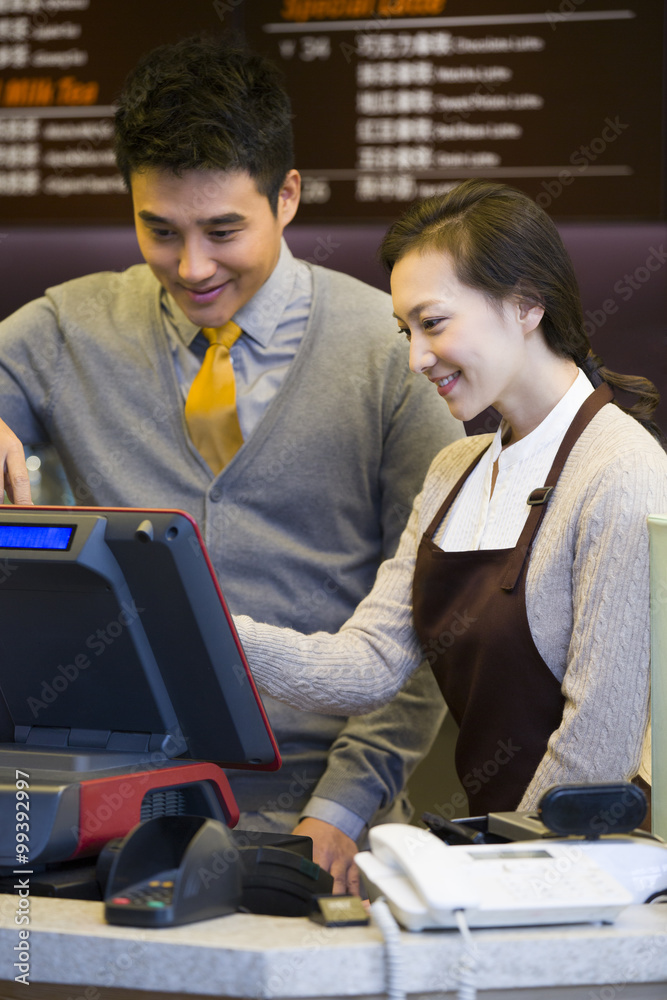 咖啡店店主和女服务员使用收银台