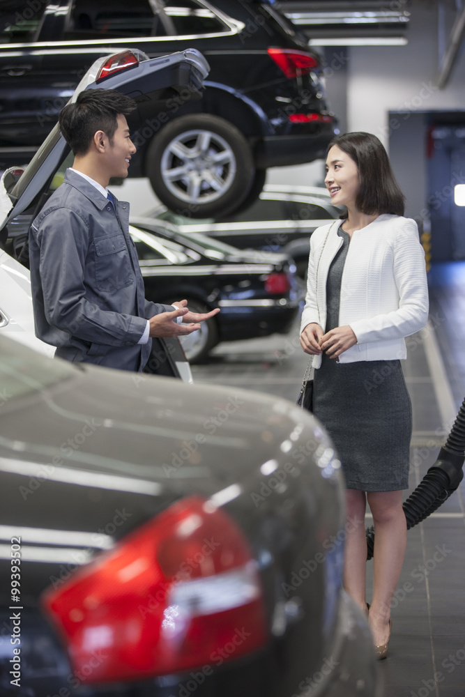 Auto mechanic talking with car owner