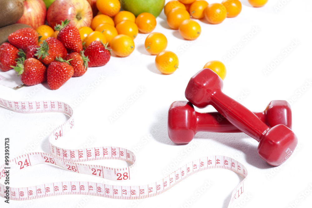 Fruits, measuring tape and dumbbell