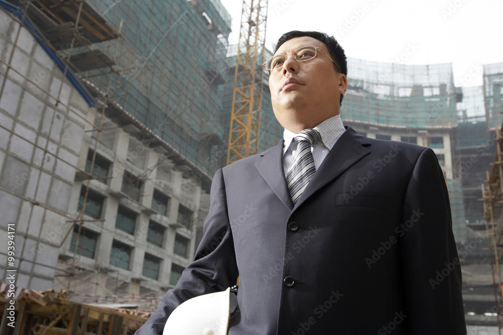 Businessman In A Construction Site Holding A Hard Hat