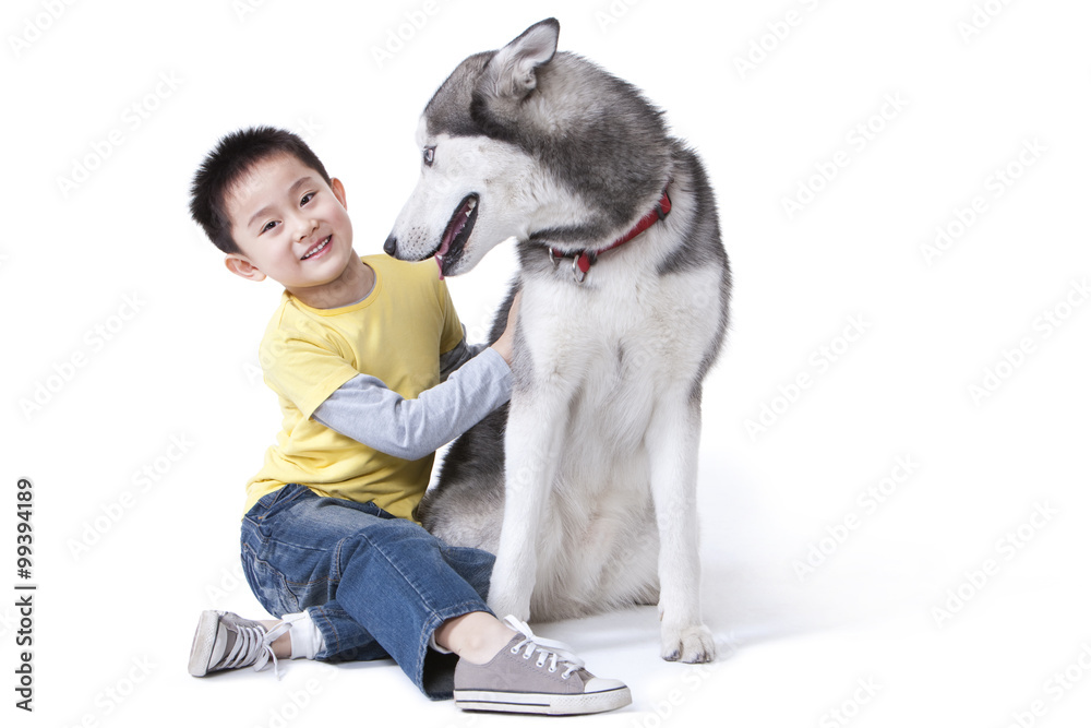 Cute little boy playing with a Husky dog