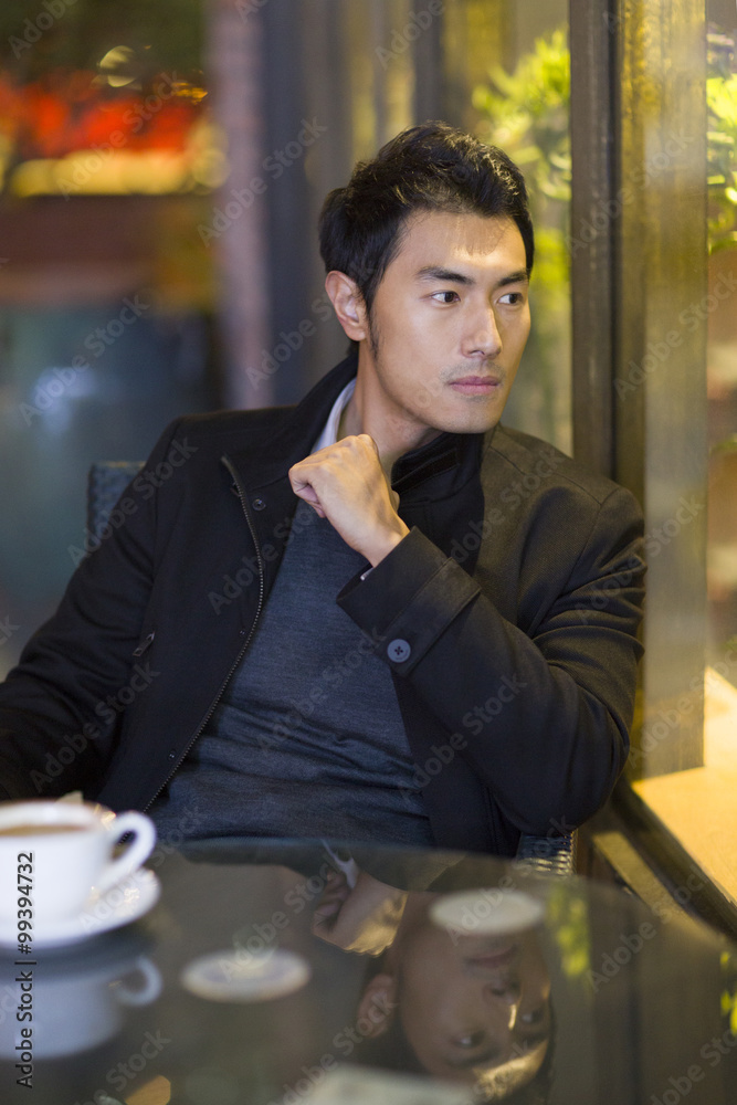 Young man drinking coffee in café