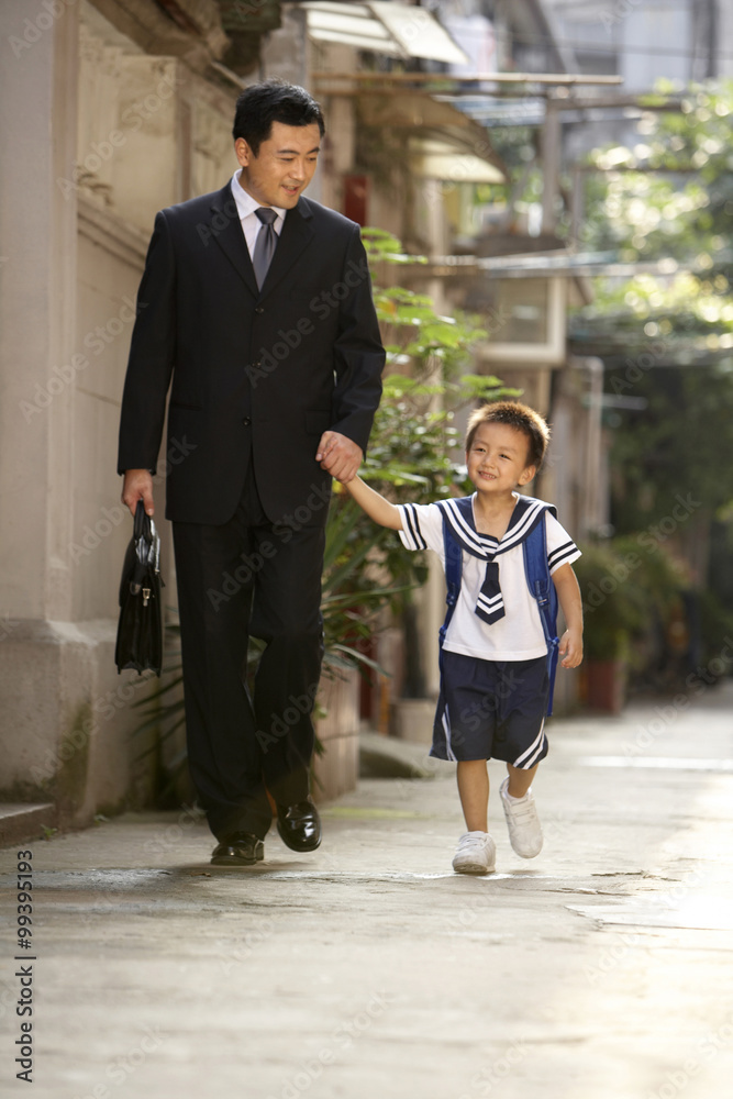 一位家长和孩子在早上上学的路上