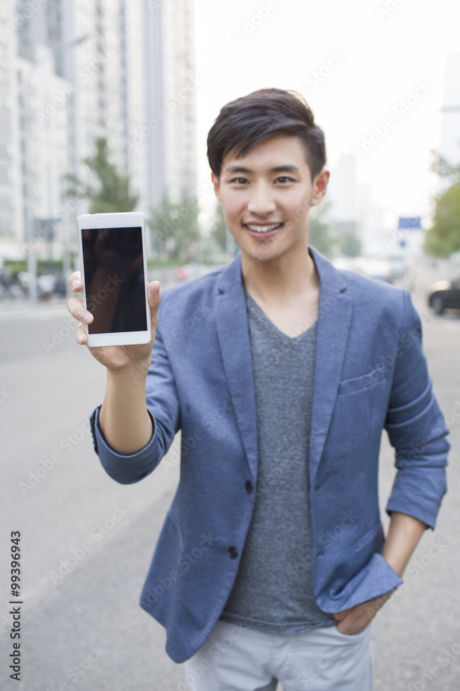 Confident young man showing smart phone