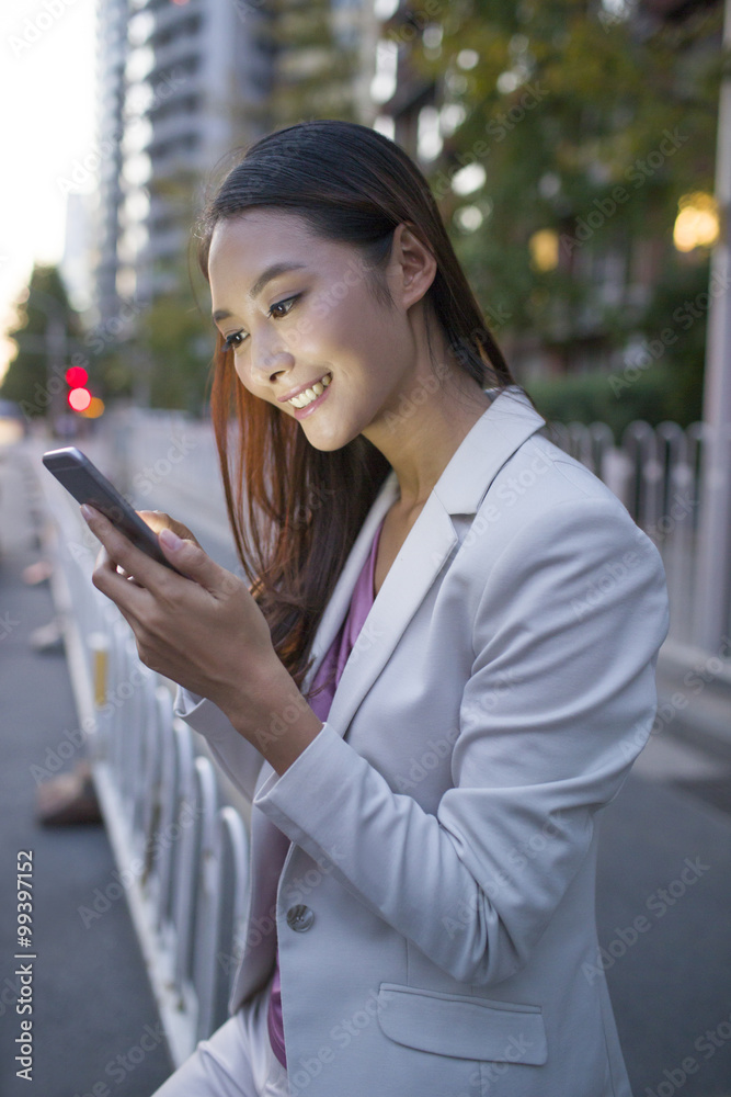 年轻女子拿着智能手机等出租车