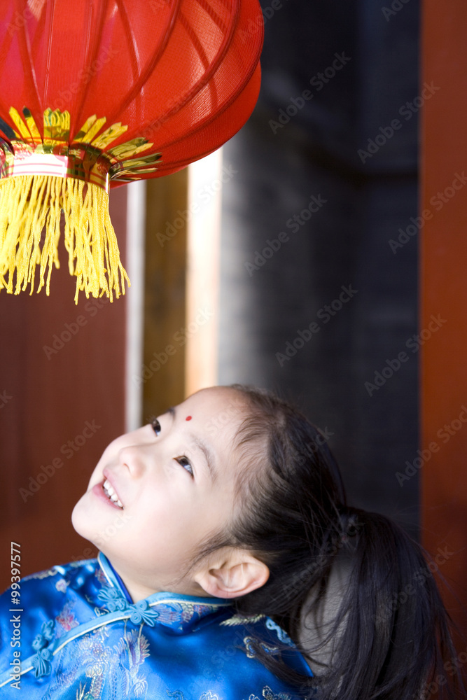 Girl In Traditional Clothing Looking Up At Lantern