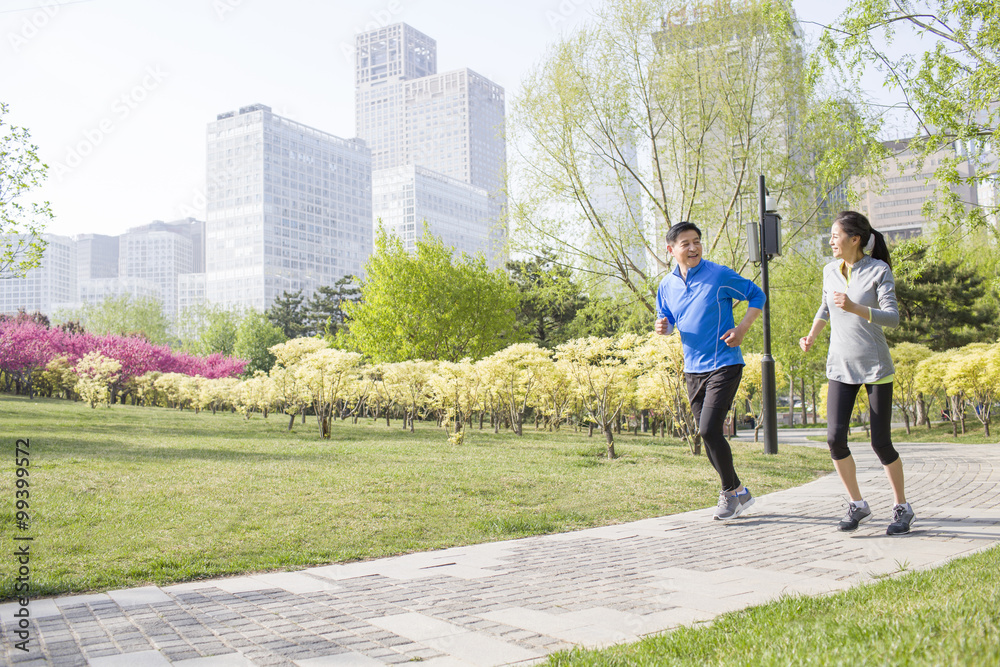 Happy mature couple running in park