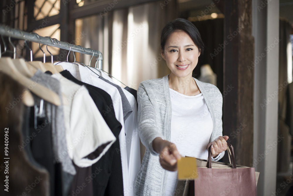 Mature woman with credit card in clothing store