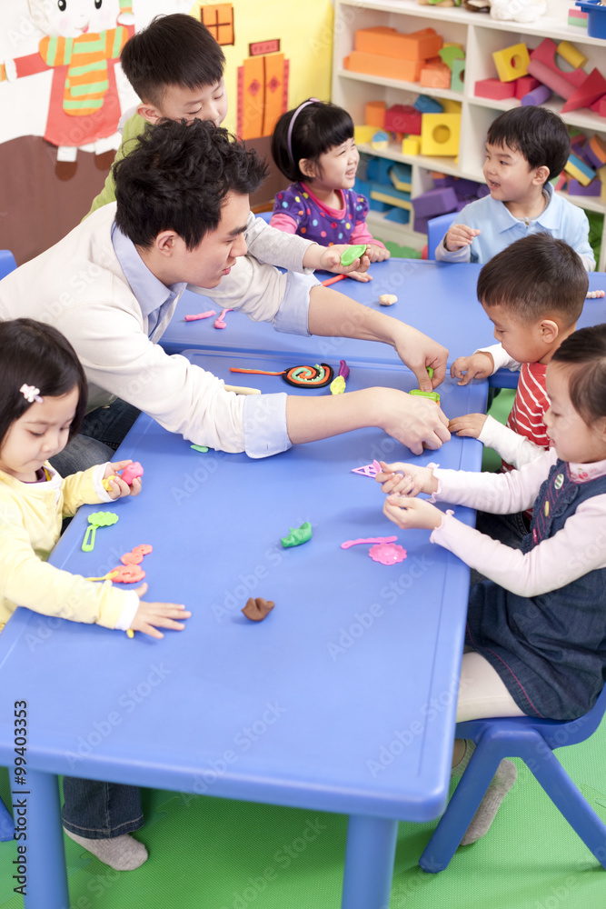 幼儿园老师和孩子们一起玩粘土