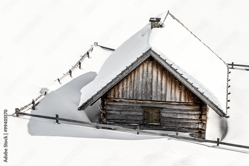 Schneebedeckte Almhütte