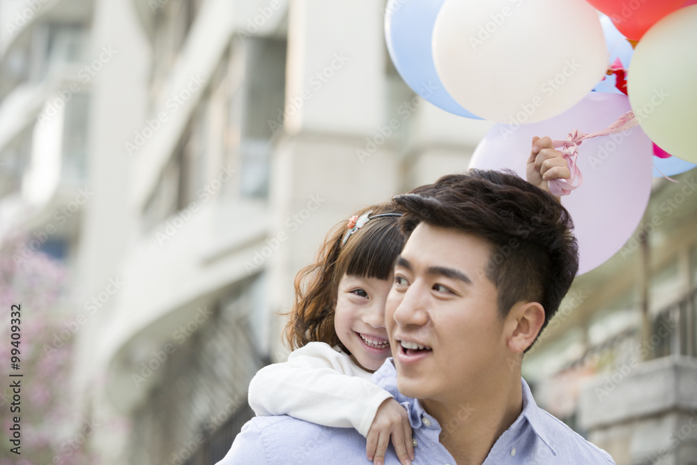 Happy father and daughter with balloons