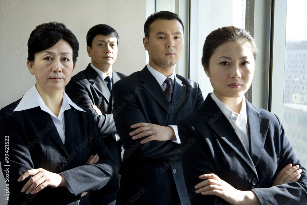 Four business professionals in front of window