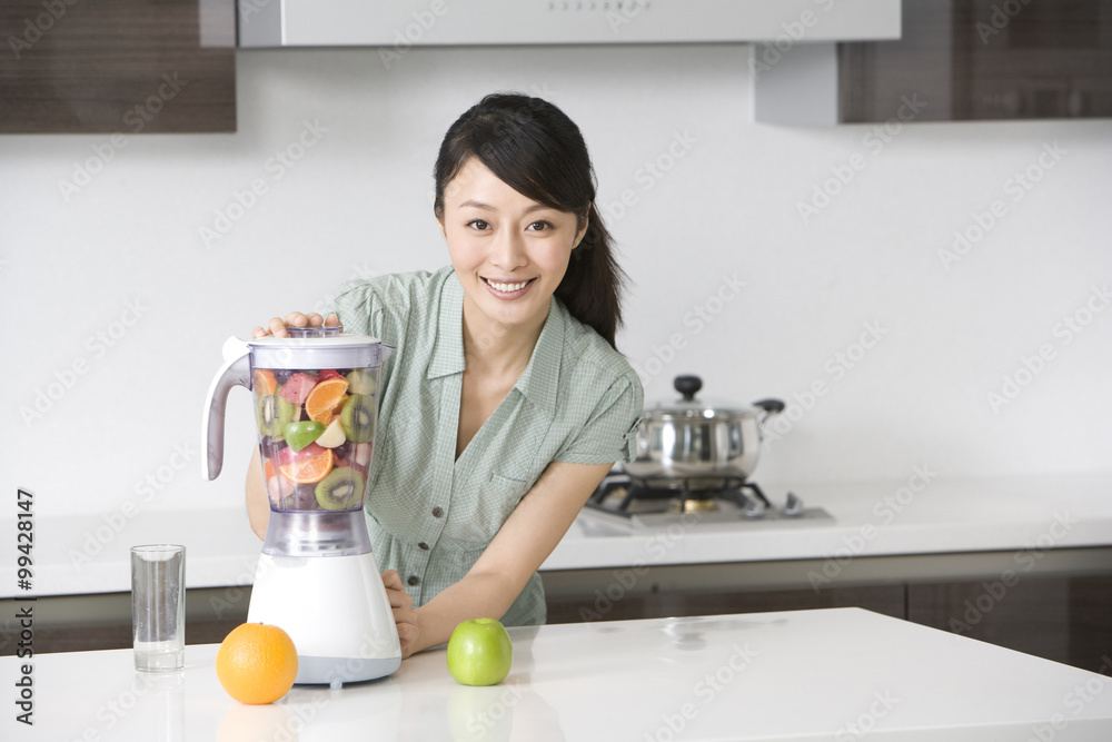 Woman making fresh fruit juice