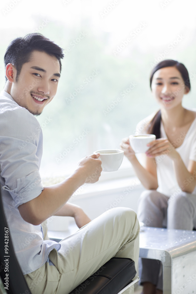 Happy young couple drinking coffee in coffee shop