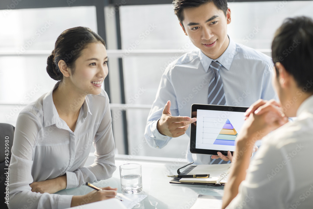 Young business people using digital tablet in office