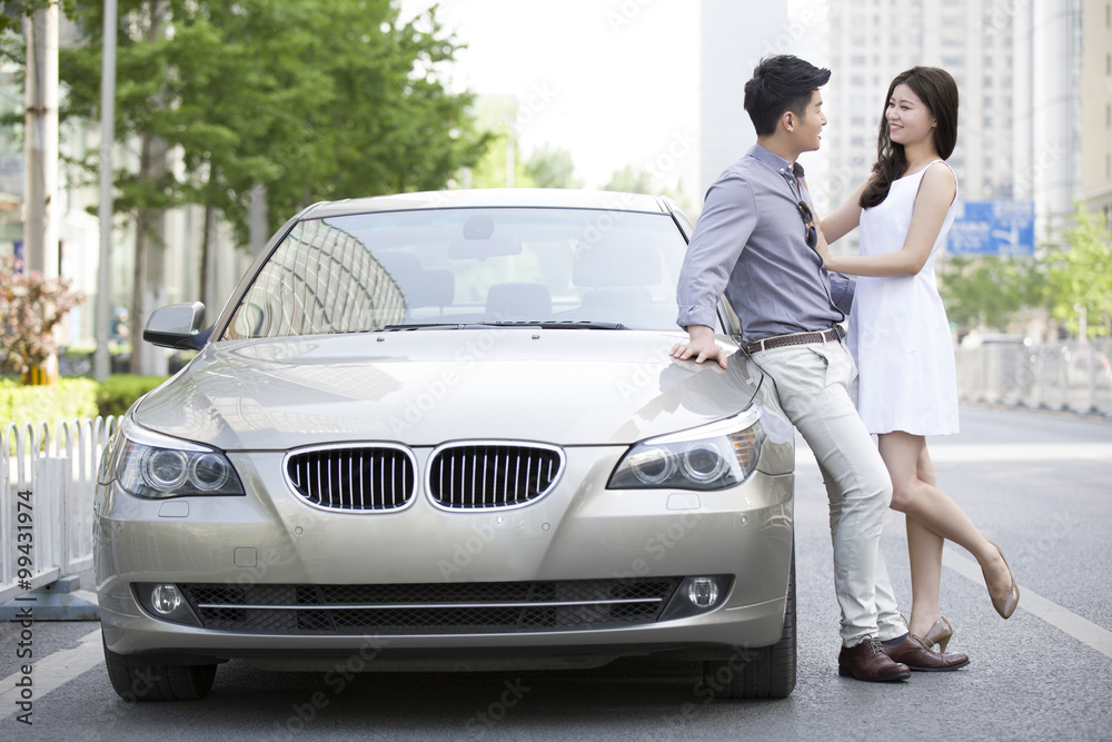 幸福的年轻夫妇和汽车