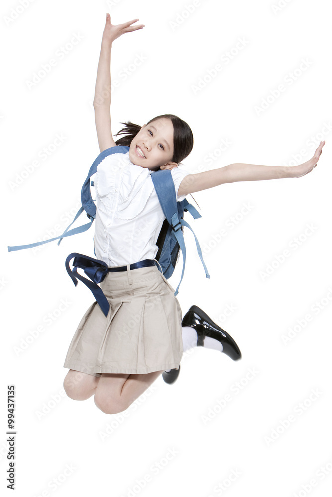 Excited schoolgirl jumping in mid-air with schoolbag on the back