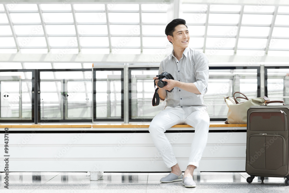 Young man with SLR camera at subway station