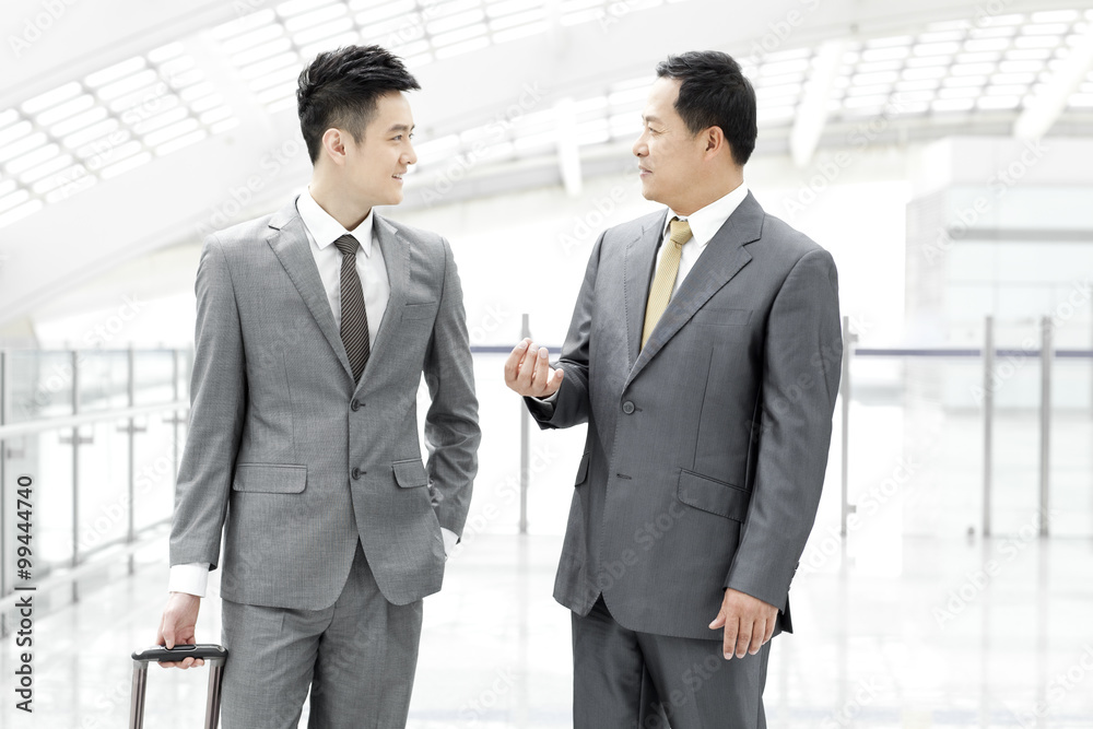 Business associates having conversation in airport lobby