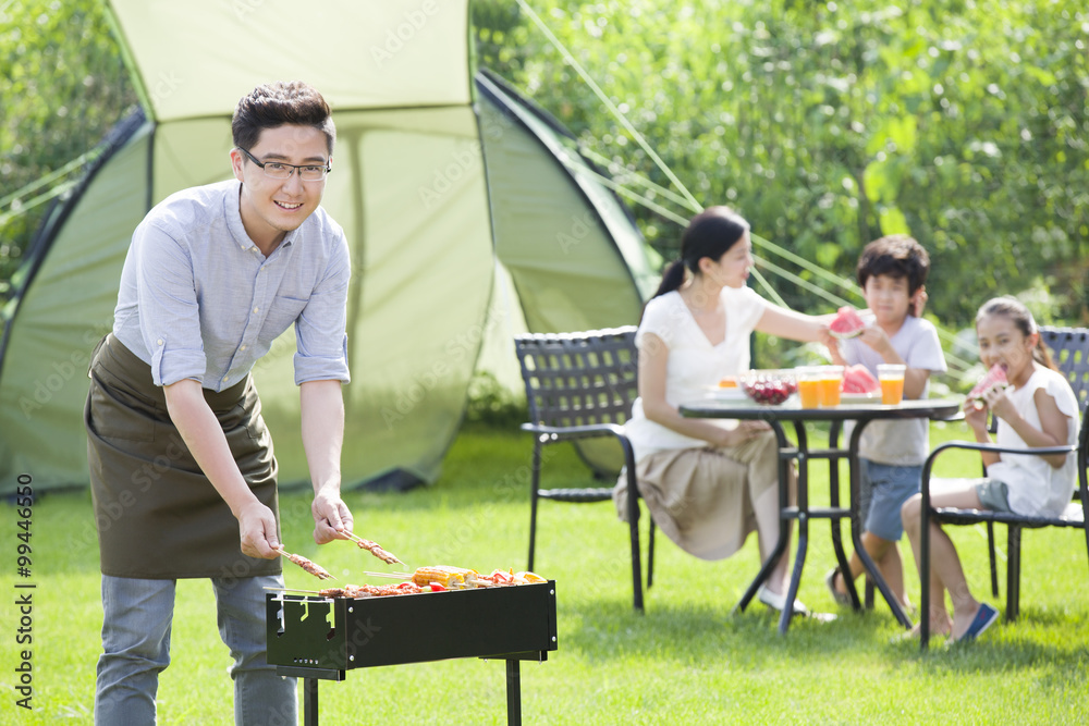 Young family barbecuing outdoors