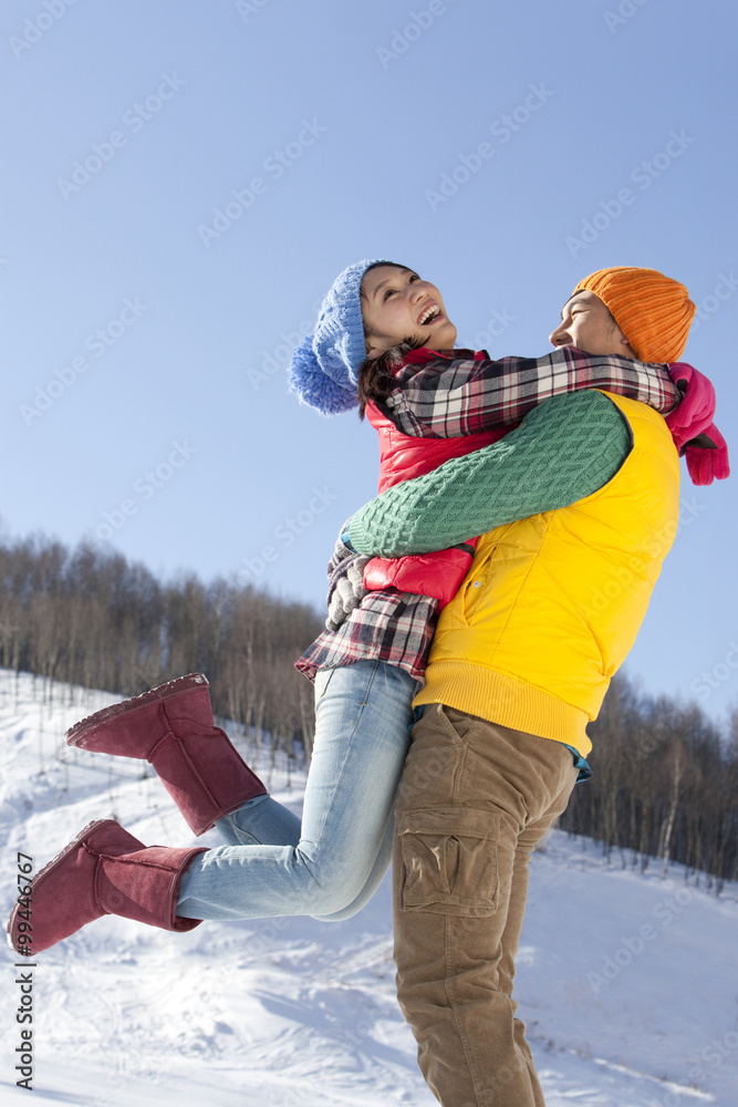 年轻夫妇在雪地里玩得很开心