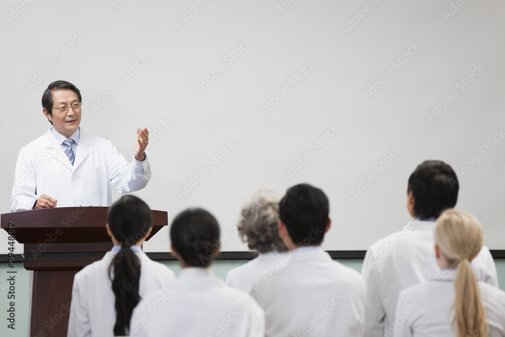 Senior doctor giving speech in boardroom