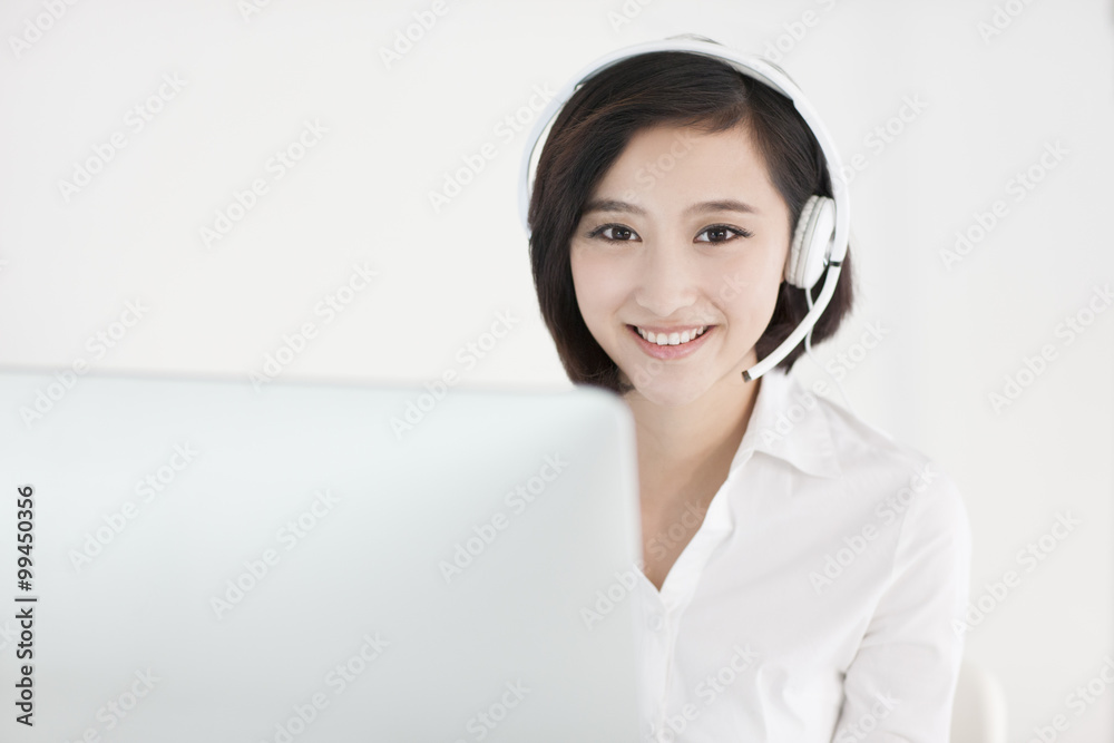 Cheerful businesswoman with headset in office