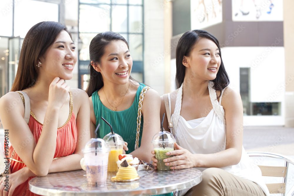 Best female friends sitting at sidewalk café