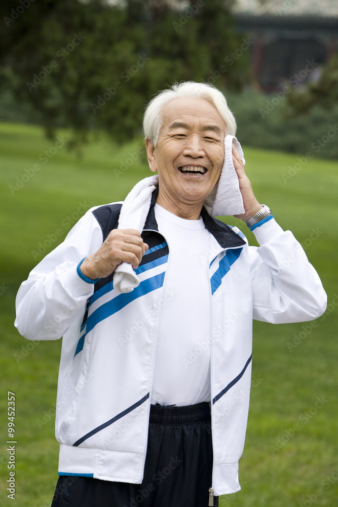 Senior Man Wiping His Head with a Towel after Exercising