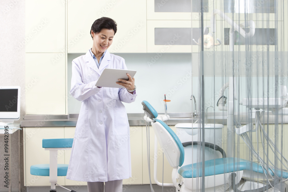 Dentist using digital tablet in dental clinic