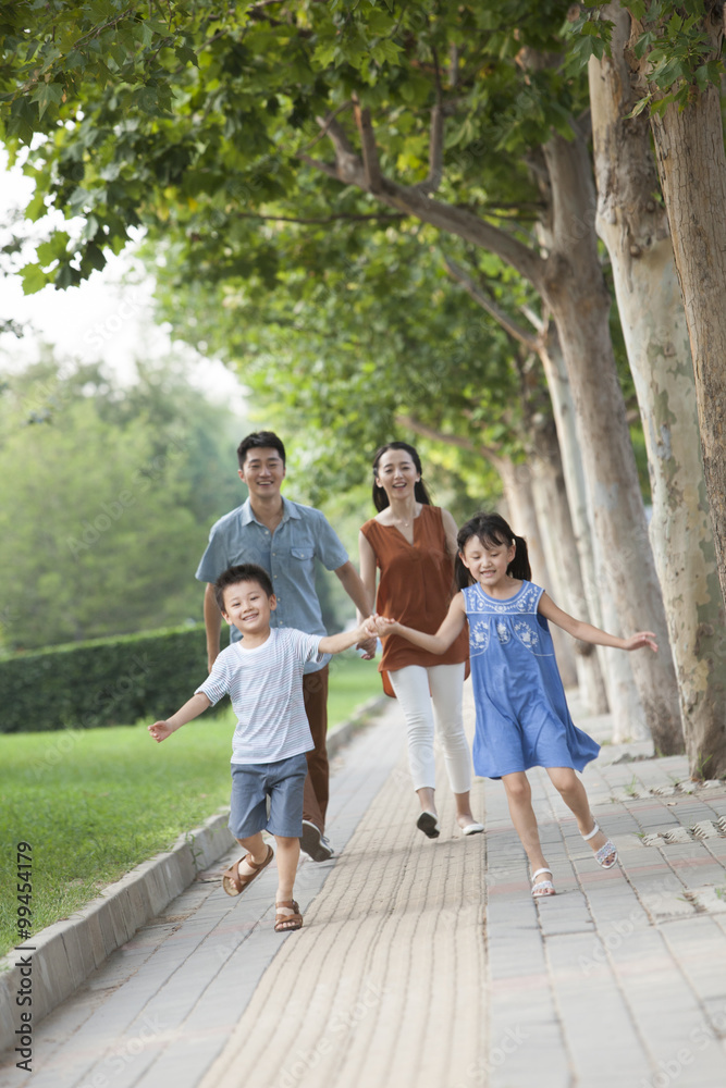 Happy brother and sister holding hands jumping