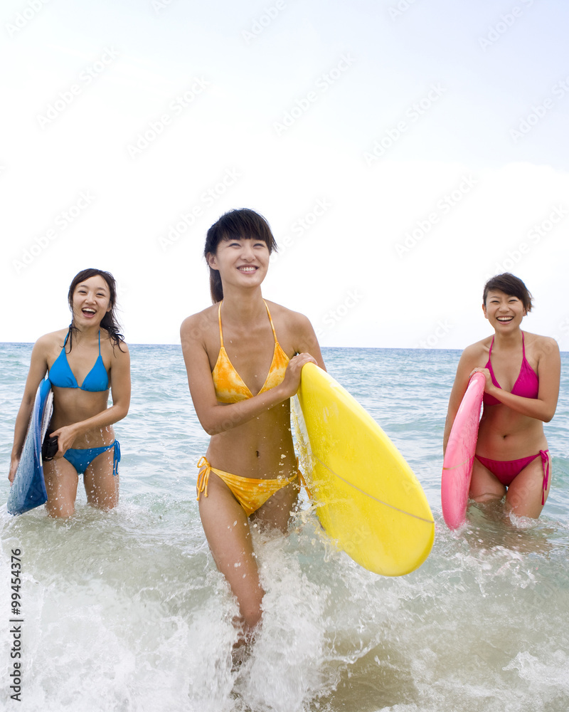 Three girls with surfboards