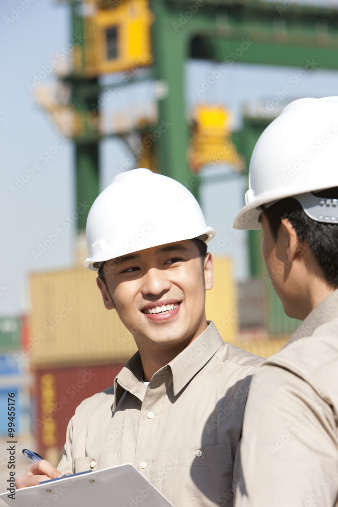 Male shipping industry workers working together