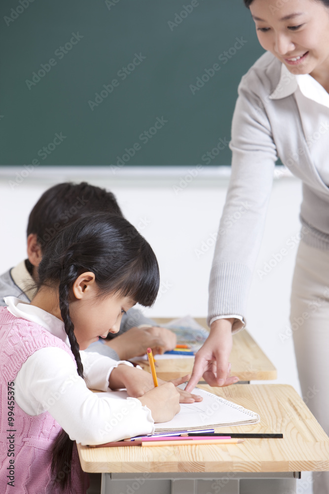 Smiling teacher teaching schoolchildren 