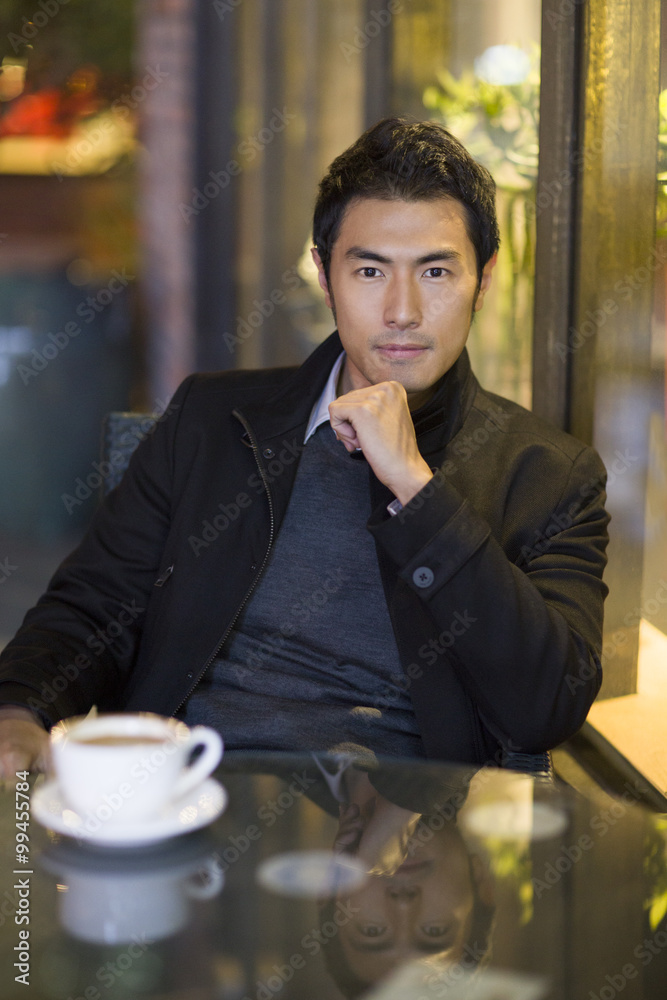 Young man drinking coffee in café