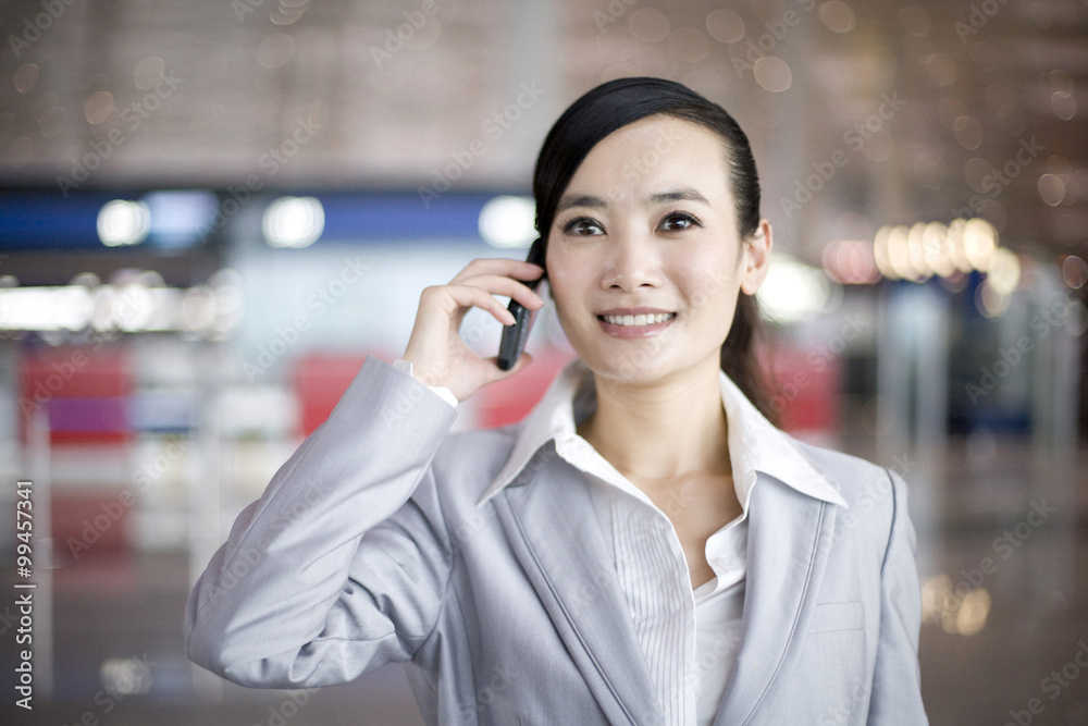 Businesswoman using cellphone in airport