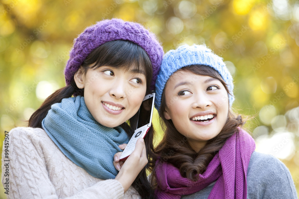 Two Young Women Listening to a Mobile Phone