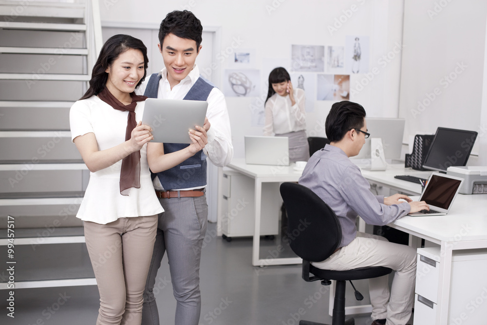 Cheerful office workers with digital tablet