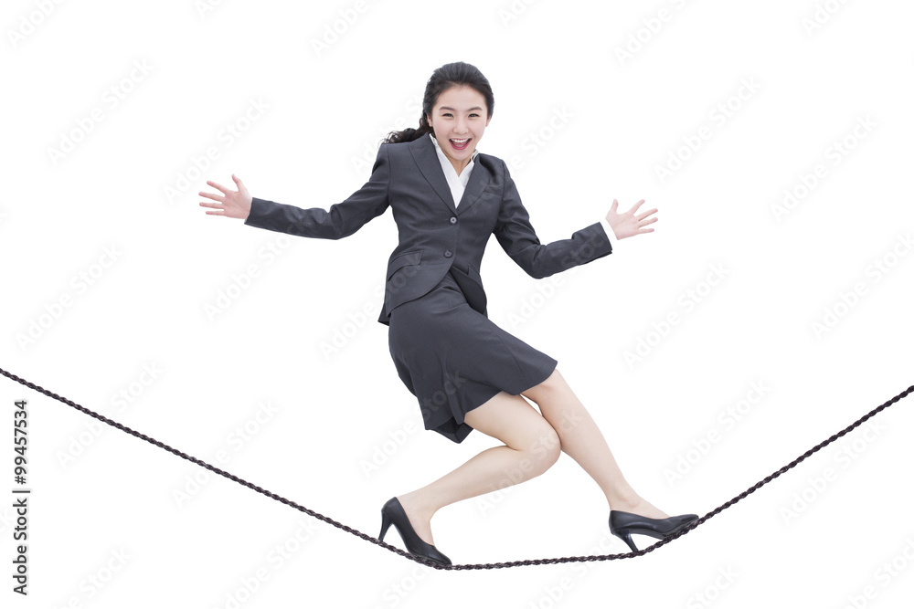 Businesswoman walking on rope