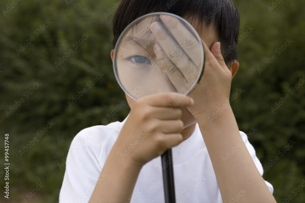 Young Boy Looking Through Magnifying Glass