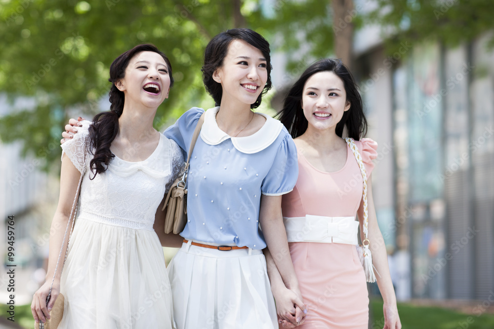 Happy female friends walking side by side