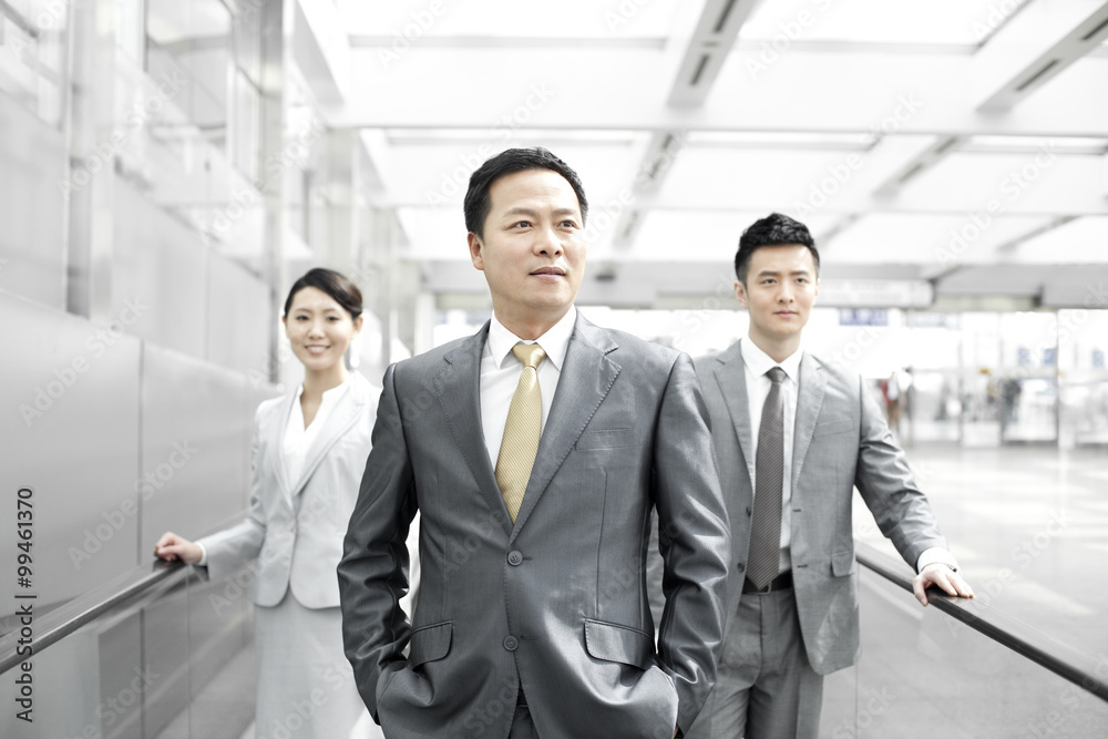 Confident business people on airport escalator