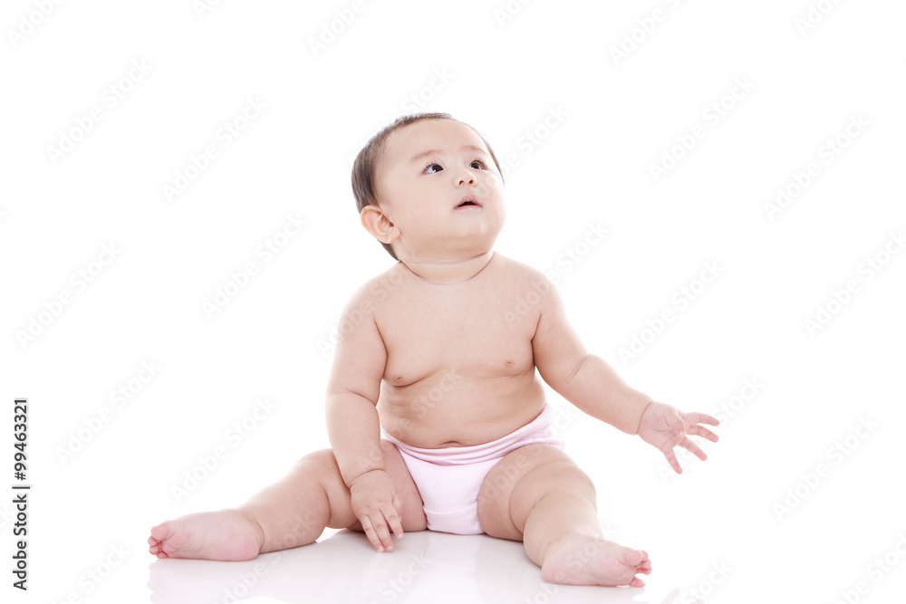 Studio shot of cute baby sitting on floor